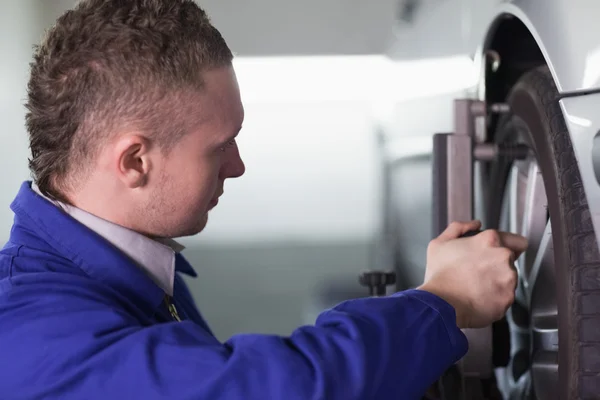 Concentrated mechanic changing a car wheel — Stock Photo, Image