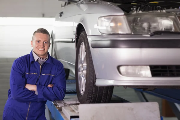 Framifrån av en leende mekaniker med armarna korsade — Stockfoto