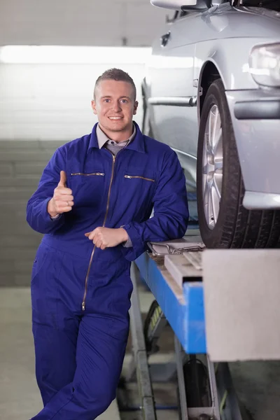 Homme debout à côté d'une voiture avec le pouce levé — Photo