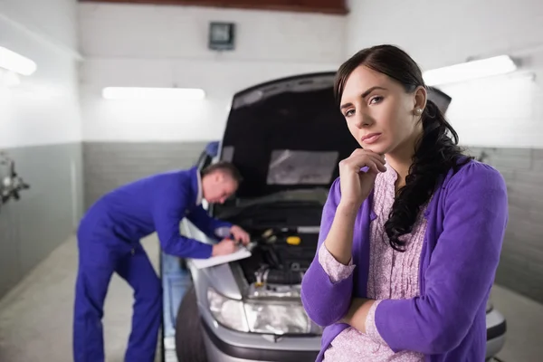 Nachdenkliche Frau neben einem Mechaniker — Stockfoto