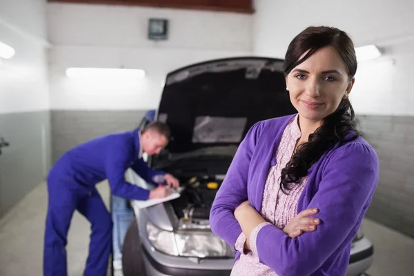 Woman with arms crossed next to a car — Stock Photo, Image