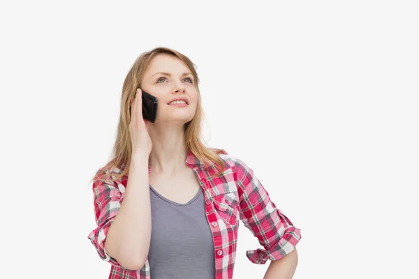 Woman holding a mobile phone while looking up — Stock Photo, Image