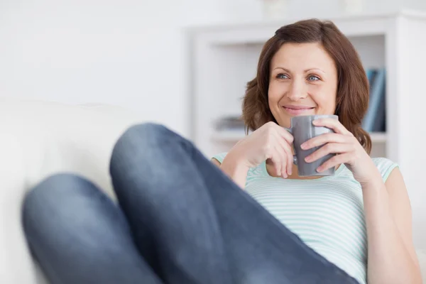 Kvinnan leende medan du håller en mugg — Stockfoto
