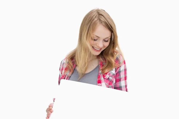 Woman holding a blank board while looking it — Stock Photo, Image