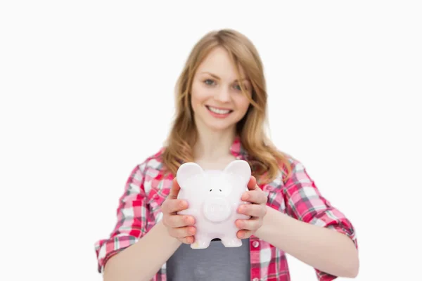 Woman holding a piggy bank while smiling — Stock Photo, Image