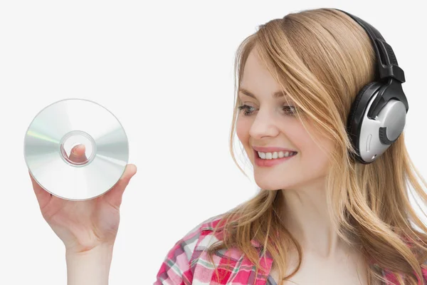 Woman holding a cd while looking it — Stock Photo, Image