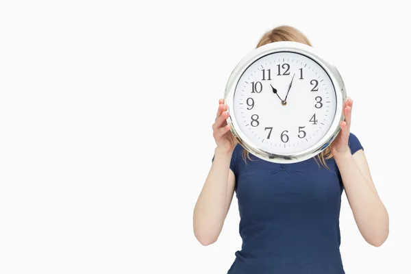 Blonde woman holding a clock — Stock Photo, Image