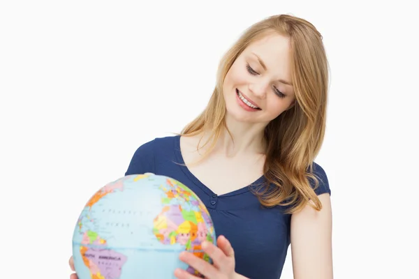 Woman holding a globe while smiling — Stock Photo, Image