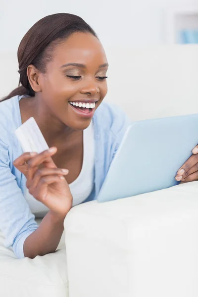 Mulher negra sorrindo enquanto segurava um cartão de crédito — Fotografia de Stock