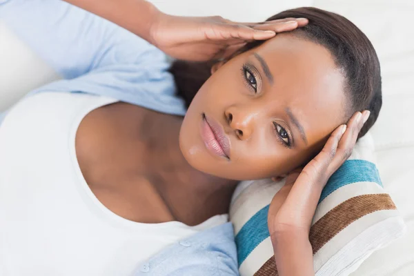 Mujer negra mintiendo mientras pone las manos en las sienes — Foto de Stock