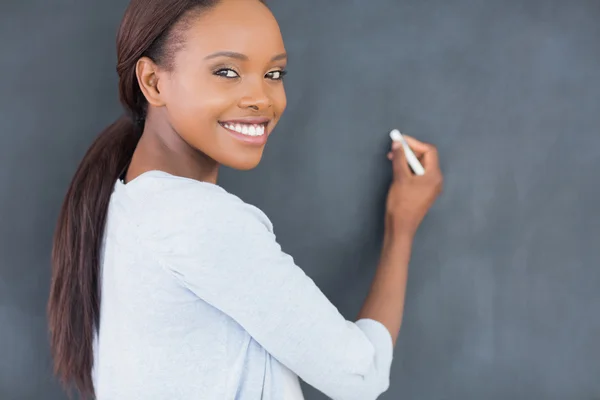 Чорна жінка посміхається, тримаючи крейду — стокове фото