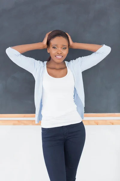 Black woman upset next to a blackboard — Stock Photo, Image