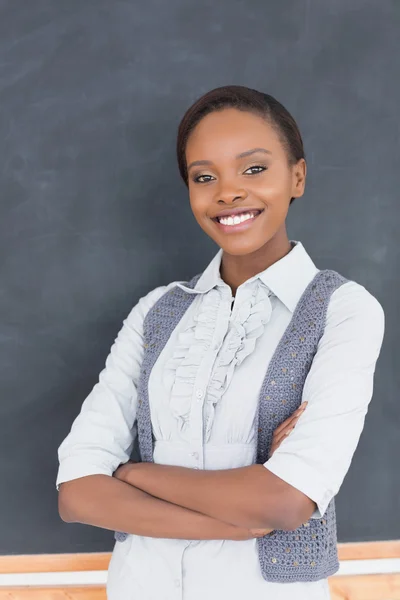 Teacher smiling next to a blackboard — Stock Photo, Image