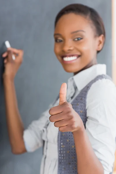 Leraar met duim omhoog schrijven op een schoolbord — Stockfoto