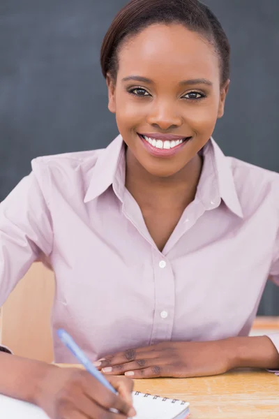 Insegnante sorridente che scrive su un quaderno — Foto Stock