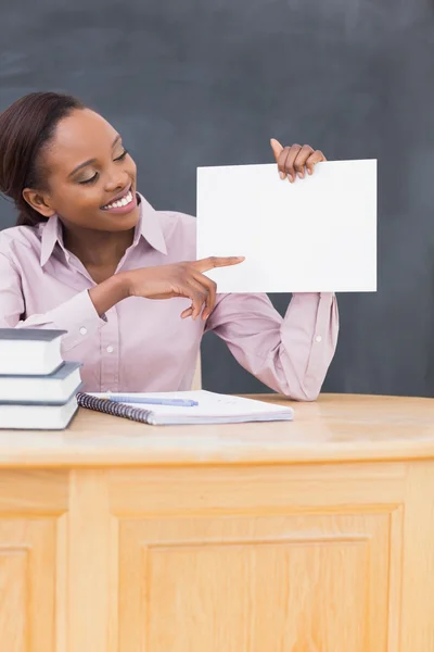 Черный учитель держит пустую бумагу за столом — стоковое фото