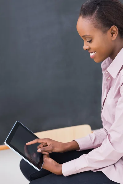 Teacher touching a tablet computer while looking it — Stock Photo, Image