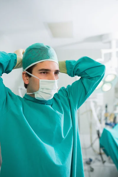 그의 마스크를 연결 하는 외과 의사의 클로즈업 — 스톡 사진