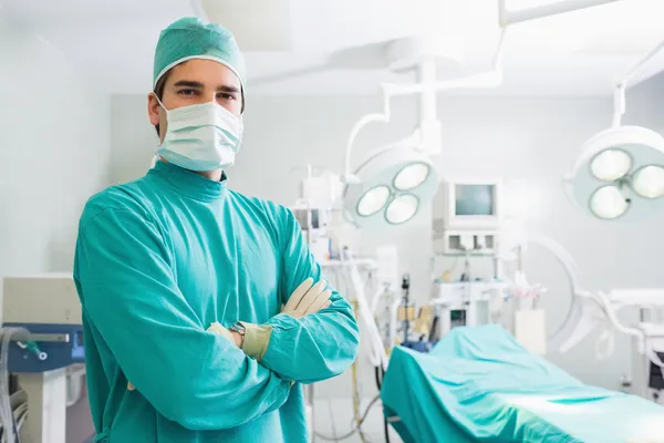 Serious surgeon standing with arms crossed — Stock Photo, Image