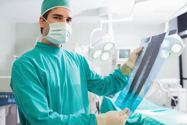 Surgeon standing while holding a X-ray — Stock Photo, Image