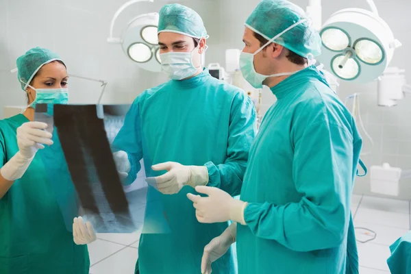Närbild av ett kirurgiskt team talar om en röntgen — Stockfoto