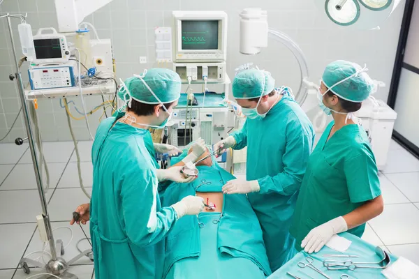 Cirujanos operando a un paciente en un quirófano —  Fotos de Stock