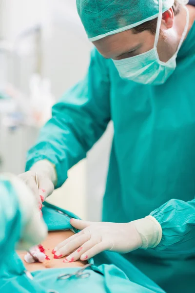 Cirurgião tocando na barriga do paciente — Fotografia de Stock