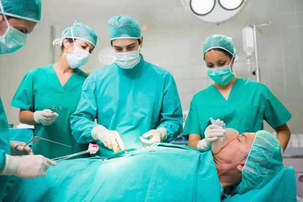 Equipe cirúrgica realizando em uma barriga paciente — Fotografia de Stock