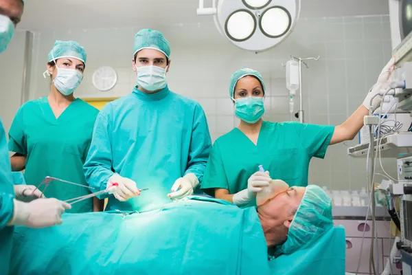 Equipo quirúrgico mirando la cámara — Foto de Stock