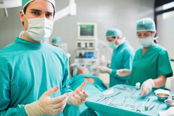 Surgeon wearing gloves with blood — Stock Photo, Image