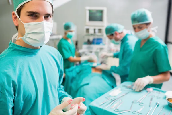 Surgeon wearing bloody gloves while looking at camera — Stock Photo, Image