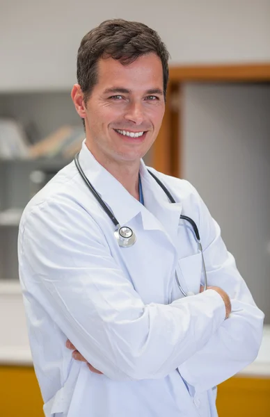 Lächelnder Arzt mit verschränkten Armen Stockbild