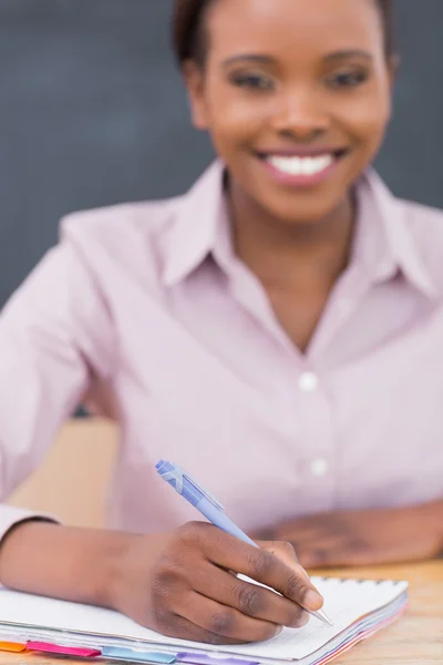 Concentrati su un insegnante che scrive su un quaderno Foto Stock