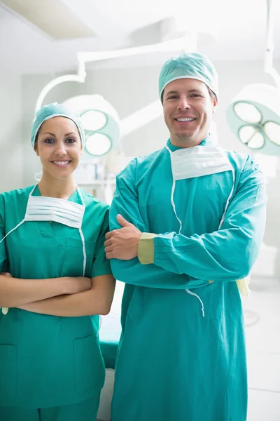 Chirurgen blicken lächelnd in die Kamera lizenzfreie Stockfotos