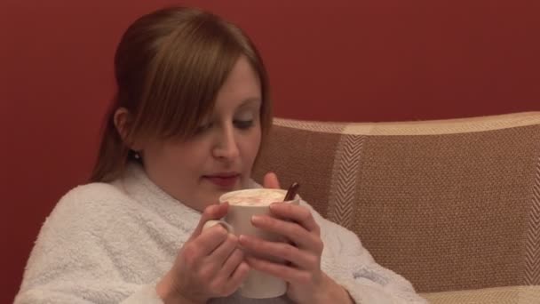 Aufnahmen einer Frau auf einer Couch, die Kaffee trinkt — Stockvideo