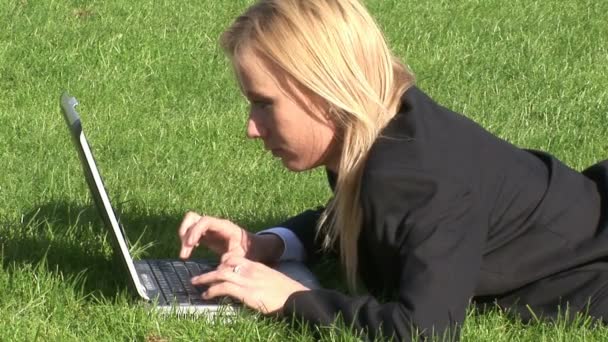 Vrouw liggen op gras met behulp van laptopcomputer — Stockvideo