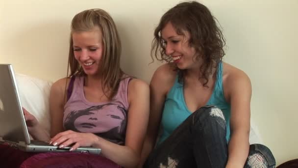 Dos chicas en la cama con ordenador portátil — Vídeo de stock