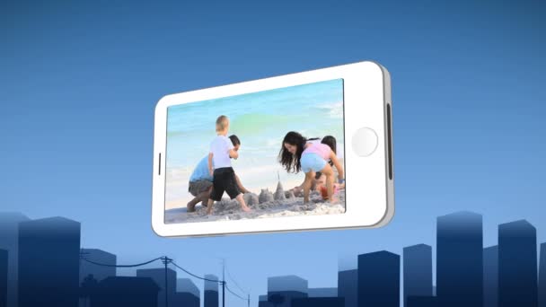 Smartphone zeigt, wie eine Familie eine Sandburg baut — Stockvideo