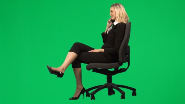 Affärskvinna som sitter på en stol på telefon mot grön skärm footage — Stockvideo