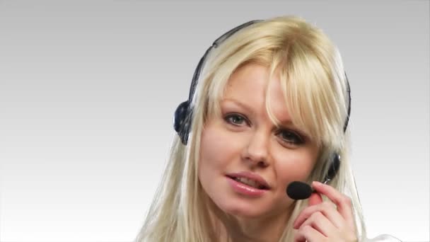 Schöne blonde Frau spricht auf einem Headset — Stockvideo