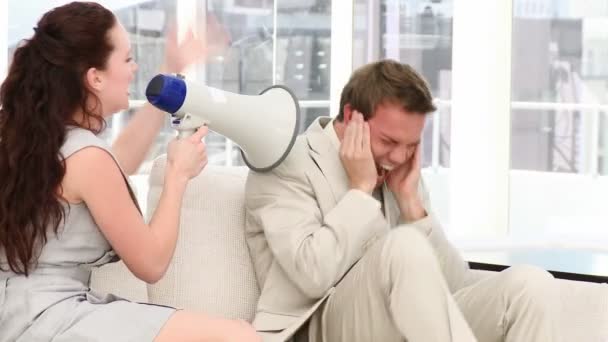 Молодая деловая женщина кричит через мегафон в уши своей коллеге — стоковое видео