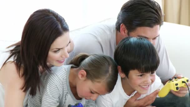 Молодая семья играет в видеоигры дома — стоковое видео