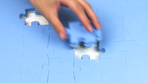 Mão colocando as duas últimas peças em um quebra-cabeça — Vídeo de Stock