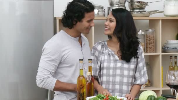 Ευτυχισμένο ζευγάρι τρώει μια σαλάτα και πίνοντας κρασί στην κουζίνα — Αρχείο Βίντεο
