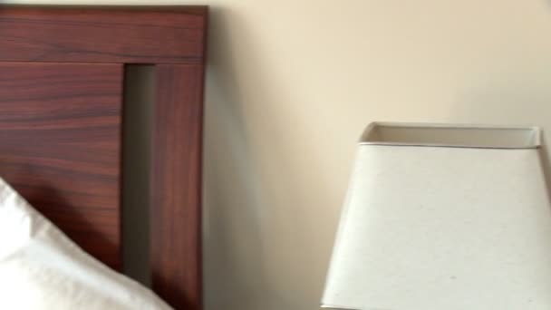Mujer elegante con auriculares en el uso de un ordenador portátil sentado en la cama — Vídeos de Stock