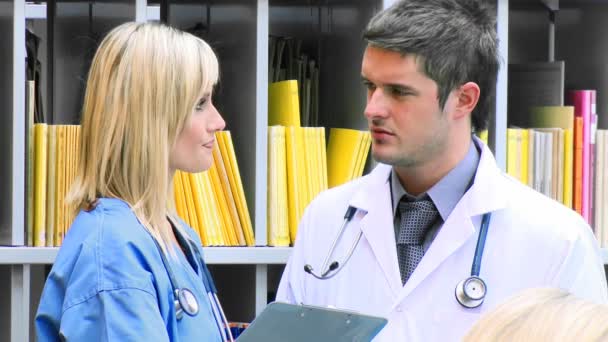 Female and male doctors examining an x-ray in hospital footage — Stock Video