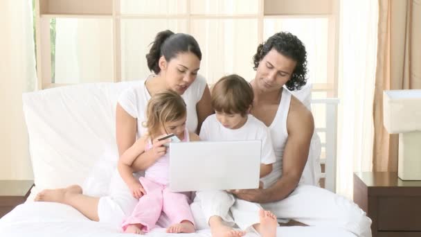 Família na cama usando um laptop . — Vídeo de Stock