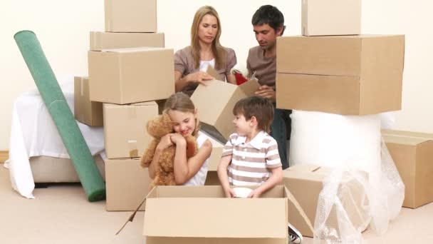 Family moving house. Parents and children unpacking boxes. — Stock Video