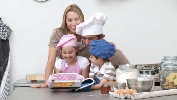 Счастливая семья печет печенье на кухне — стоковое видео