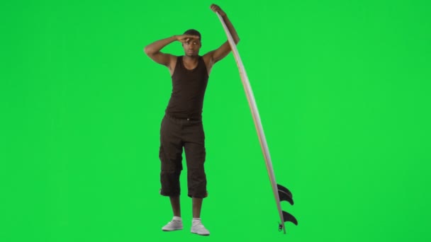 Ethnic boy with a surfboard against green screen — Stock Video